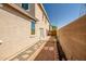 Enclosed backyard with paver pathway, patio, small planter box and exterior wall, promoting a private outdoor space at 17802 N 114Th Ln, Surprise, AZ 85378