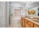 Bathroom showcasing a double vanity, soaking tub, and separate glass-enclosed shower at 17802 N 114Th Ln, Surprise, AZ 85378