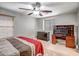 Comfortable bedroom includes a ceiling fan, a window for natural light, desk, and dresser at 17802 N 114Th Ln, Surprise, AZ 85378