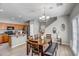Open-concept dining area with a wooden table set, view into the kitchen and modern light fixture at 17802 N 114Th Ln, Surprise, AZ 85378