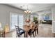 Bright dining room with a wooden table, seating for six, and double doors to the outside at 17802 N 114Th Ln, Surprise, AZ 85378