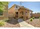 Charming two-story home exterior with a stone archway, landscaping, and walkway at 17802 N 114Th Ln, Surprise, AZ 85378