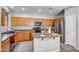 Well-lit kitchen featuring stainless steel appliances, an island, and wood cabinets at 17802 N 114Th Ln, Surprise, AZ 85378