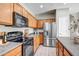 Modern kitchen featuring stainless steel appliances, wood cabinets, and light countertops at 17802 N 114Th Ln, Surprise, AZ 85378