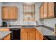 Close-up of the kitchen sink area featuring gray countertops and oak cabinets at 17802 N 114Th Ln, Surprise, AZ 85378