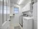 Functional laundry room with white cabinets, modern washer and dryer, and tiled flooring at 17802 N 114Th Ln, Surprise, AZ 85378