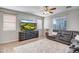 Bright living room featuring a large TV atop a cabinet, a cozy rug, and a plush gray sectional at 17802 N 114Th Ln, Surprise, AZ 85378