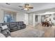 Open-concept living room with a gray sectional sofa, light wood floors, and a view into the dining area at 17802 N 114Th Ln, Surprise, AZ 85378