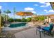 Beautiful backyard features a lush pool with rocks and waterfalls, covered patios and landscaping at 18030 W Caribbean Ln, Surprise, AZ 85388