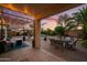 Beautiful backyard with outdoor dining set, covered patio, lush foliage, and a refreshing pool at 18030 W Caribbean Ln, Surprise, AZ 85388