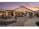 Spacious backyard features beautiful rock landscaping, covered patio, and seating for many at 18030 W Caribbean Ln, Surprise, AZ 85388