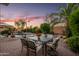 Backyard dining set with seating for six, beautiful landscaping, and swimming pool in view at 18030 W Caribbean Ln, Surprise, AZ 85388