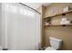 Bathroom with decorative flower and three roles of toilet paper on natural wood shelving at 18030 W Caribbean Ln, Surprise, AZ 85388