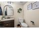 Cozy half bathroom featuring modern fixtures, stylish vanity with granite countertop, and decorative wall art at 18030 W Caribbean Ln, Surprise, AZ 85388