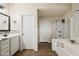 Bright primary bathroom featuring a white vanity, neutral walls, and a separate shower and soaking tub at 18030 W Caribbean Ln, Surprise, AZ 85388