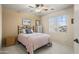 Cozy bedroom with neutral walls, ceiling fan, and a window with neighborhood views at 18030 W Caribbean Ln, Surprise, AZ 85388