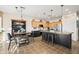 Modern kitchen with stainless steel appliances, a black island with bar stools, and a dining table at 18030 W Caribbean Ln, Surprise, AZ 85388