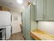 Well-organized laundry room featuring stacked washer and dryer, sage green cabinets, and butcher block countertops at 18030 W Caribbean Ln, Surprise, AZ 85388