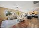 Spacious living room featuring hardwood flooring, a plush sectional sofa, and a view of the kitchen at 18030 W Caribbean Ln, Surprise, AZ 85388