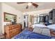 Bedroom with a wooden dresser, fan, and closet at 19302 W Melvin St, Buckeye, AZ 85326