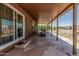 A covered patio with stone flooring, outdoor seating, and views of the landscape at 19302 W Melvin St, Buckeye, AZ 85326