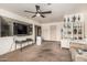 Carpeted living room with a ceiling fan, a large TV and a built in storage unit at 19302 W Melvin St, Buckeye, AZ 85326