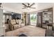 Carpeted living room with a ceiling fan, big window and built in storage at 19302 W Melvin St, Buckeye, AZ 85326