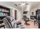 Comfortable living room featuring cozy recliners, a wood burning stove, and a well-stocked bookshelf at 19302 W Melvin St, Buckeye, AZ 85326