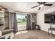Carpeted living room with a ceiling fan, big window and built in storage at 19302 W Melvin St, Buckeye, AZ 85326
