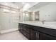 Modern bathroom with double sink vanity, large mirror, and glass-enclosed shower at 19338 S 212Th Pl, Queen Creek, AZ 85142