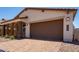 Lovely home with a two-car garage, brick detailing, desert landscaping, and a paver driveway at 19338 S 212Th Pl, Queen Creek, AZ 85142