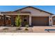 Charming home featuring a brick facade, desert landscaping, and a spacious two-car garage at 19338 S 212Th Pl, Queen Creek, AZ 85142