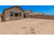 Spacious backyard of beige single-story home with a covered patio and block fence at 19354 S 212Th Pl, Queen Creek, AZ 85142