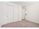 Spacious bedroom with a neutral carpet, with closet and view into hallway at 19354 S 212Th Pl, Queen Creek, AZ 85142