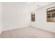 Bright, empty bedroom with neutral carpet and views from multiple windows at 19354 S 212Th Pl, Queen Creek, AZ 85142