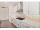 Kitchen with stainless hood vent, stovetop, white cabinets, and neutral countertops at 19354 S 212Th Pl, Queen Creek, AZ 85142