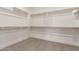 A large, walk-in closet featuring multiple wooden racks and shelving for ample storage space at 19434 S 212Th Pl, Queen Creek, AZ 85142