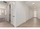 Bright hallway showcasing tile flooring, a laundry room, and access to other areas of the house at 19434 S 212Th Pl, Queen Creek, AZ 85142
