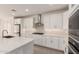 Well-equipped kitchen featuring stainless steel appliances, a modern range hood, and sleek white cabinetry at 19434 S 212Th Pl, Queen Creek, AZ 85142