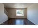 Bright living room with wood floors, large window, and staircase at 19601 N 7Th St # 1003, Phoenix, AZ 85024