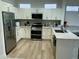 Well-equipped kitchen features stainless steel appliances, granite countertops, and bright hardwood flooring at 19882 N Crimson Ridge Way, Surprise, AZ 85374