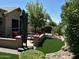 Cozy patio with artificial grass, lush landscaping, and comfortable seating, perfect for outdoor relaxation at 19882 N Crimson Ridge Way, Surprise, AZ 85374