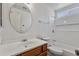 Bright bathroom featuring a white vanity, oval mirror, and a shower-tub combo with white tiling at 20352 N 109Th Dr, Peoria, AZ 85373
