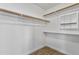Walk-in closet with wood shelving, hanging rods and wood look tile flooring at 20352 N 109Th Dr, Peoria, AZ 85373