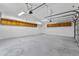 Large garage with overhead storage and a clean, painted floor offering versatile space for vehicles and projects at 20352 N 109Th Dr, Peoria, AZ 85373