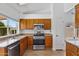 Traditional kitchen features stainless steel appliances, tile flooring, and wood cabinetry at 20352 N 109Th Dr, Peoria, AZ 85373