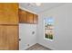 Functional laundry room equipped with built-in storage cabinets and a window overlooking the exterior at 20352 N 109Th Dr, Peoria, AZ 85373