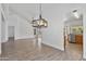 Open living room with tile floors, a modern chandelier, and an adjacent kitchen at 20352 N 109Th Dr, Peoria, AZ 85373