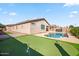 Backyard oasis featuring a sparkling pool, putting green, and a lush grassy area at 21075 E Estrella Rd, Queen Creek, AZ 85142