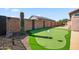Private backyard with a putting green, desert landscaping, and block wall fencing at 21075 E Estrella Rd, Queen Creek, AZ 85142